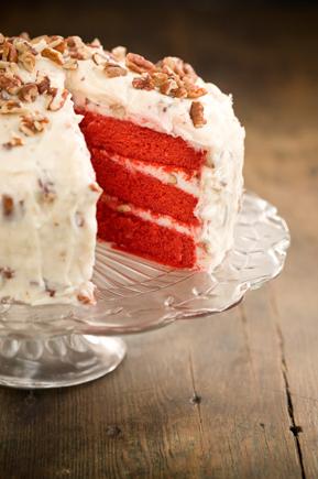  A delectable slice of Red Velvet Cake with layers of creamy icing and a dusting of cocoa powder